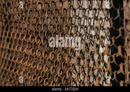 The texture of the metal mesh on a white background. Torn steel, metal mesh with holes. fence Stock Photo