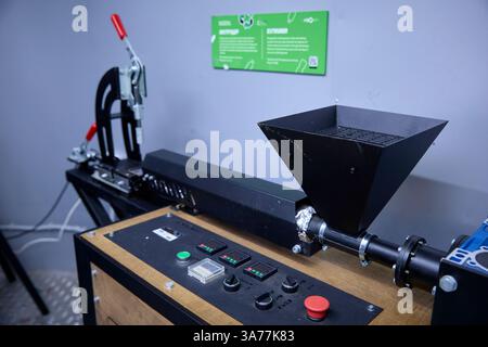 Industrial ingenuity, a homemade extruder machine stands ready, sparking curiosity and innovation in a workshop setting, hinting at resourceful creati Stock Photo