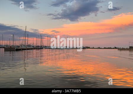 Reddish sunset reflected in the sea, in the port of La Rapita in the Ebro Delta Stock Photo