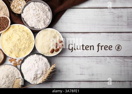 Gluten-free flours in bowls on white wooden table, top view Stock Photo