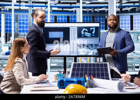 Shareholders meet with solar panels plant managers to ask technical questions. Investors doing due diligence before investing in photovoltaics factory, evaluating production processes efficiency Stock Photo