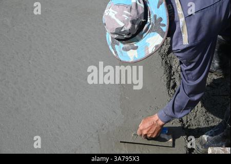 Concrete workers are pouring concrete to make the floor and finishing it to be smooth. Stock Photo
