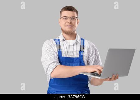Male contractor using laptop on light background Stock Photo