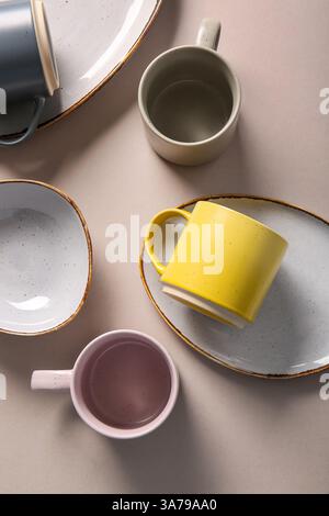 Set of ceramic mugs and plates on grey background Stock Photo