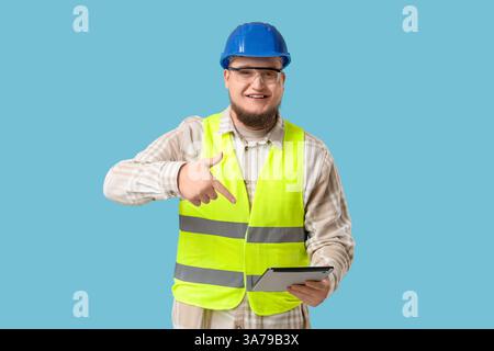 Male engineer with tablet computer on blue background Stock Photo