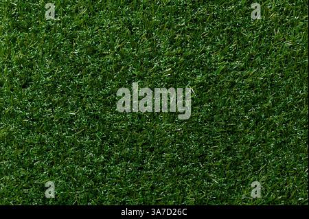 Artificial turf, plastic grass, surface and background. Green colored surface of synthetic fibers made to look like natural grass. Stock Photo