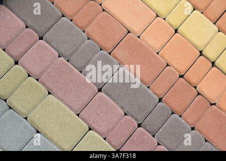 Multicolored paving slabs for road paving by mosaic on shop window. Construction Stock Photo