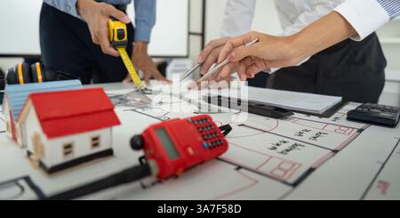 Design and Collaboration. Team actively engaged in drafting building layouts and discussing architectural features. Stock Photo