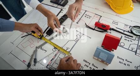 Architecture and Collaboration. Construction team analyzing design blueprints and planning measurements for a building project. Stock Photo