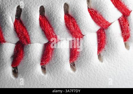 Macro view of baseball red stitches on white leather for athletic equipment Stock Photo