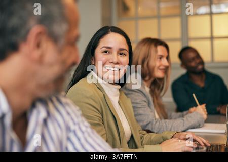 Smiling businesswoman talking with male colleague during meeting in office Stock Photo