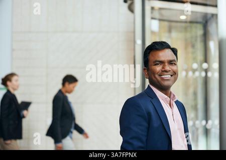 Portrait of smiling male entrepreneur at office lobby Stock Photo