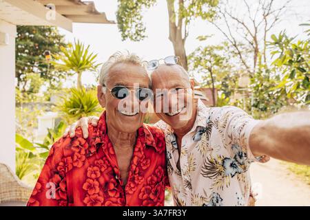 Portrait of smiling senior man taking selfie with boyfriend Stock Photo