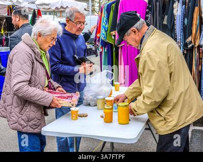 Elderly couple buying locally produced honey at the Wednesday Arab market in Chetellerault, Vienne (86), France. Stock Photo