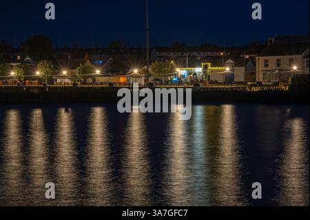A nighttime picture of the lights of Watchet reflecting across the inner harbour at Watchet Marina, Watchet, Somerset, England, UK. Stock Photo