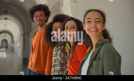 Group happy diversity students in university corridor talking smiling laughing four multiracial friends in college African American man guy with Stock Photo