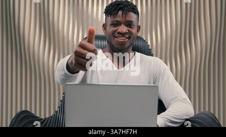 Smiling African American man guy male hacker e-business typing keyboard laptop futuristic cybersecurity coding business online crypto blockchain Stock Photo