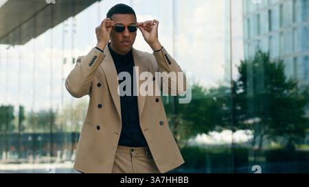 Happy funny fooling having fun African American businessman business man male guy turning around spin rotate put on sunglasses black glasses stylish Stock Photo