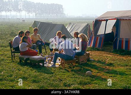 France. Group of young people sitting by tents outdoors. Camping. Stock Photo