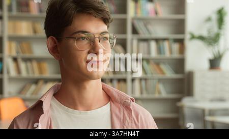 Portrait smiling happy positive Caucasian teen boy student guy male pupil man teenager in glasses looking smile at camera studying learning in school Stock Photo