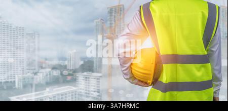 Civil engineer architect standing holding a safety helmet on construction and city background, Construction site plans to build high-rise buildings, E Stock Photo