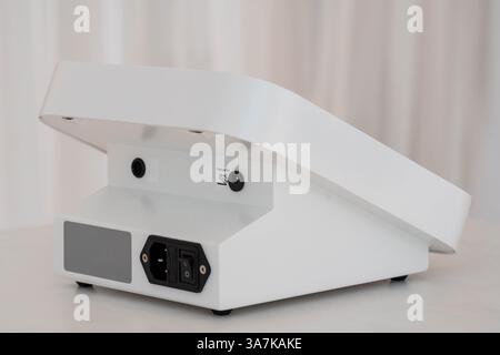 Modern Compact Electronic Device in White Housing with Power Input and Minimalist Design. Stock Photo