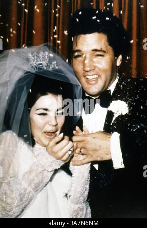 Elvis Presley and Priscilla Presley wedding photo, wearing tuxedo and wedding dress, smiling and holding hands, during a press conference following their marriage, May, 1967. Photo credit Smith Collection/Gado/Getty Images Stock Photo - Elvis Presley and Priscilla Presley wedding photo, wearing tuxedo and wedding dress, smiling and holding hands, during a press conference following their marriage, May, 1967. Photo credit Smith Collection/Gado/Getty Images Stock Photo -