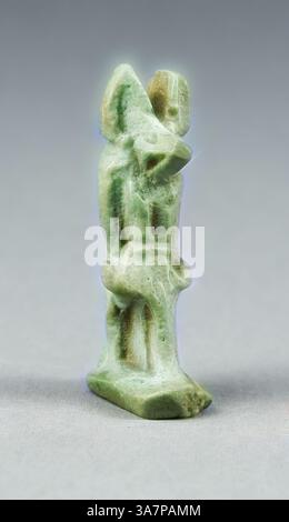 A finely carved green stone sculpture depicting two figures in an intimate pose, showcasing intricate details and natural texture., Classic art with a modern twist reimagined by Artotop, Amulet of the God Anubis, Late Period, Dynasties 26–31 (664–332 BC), Egyptian, Egypt, Faience Stock Photo