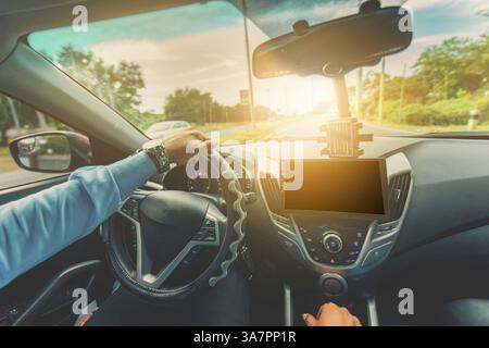 Driver hands on the steering wheel while driving on the asphalt. View of the driver hands driving on the highway Stock Photo