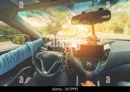 View of the driver hands driving on the highway. Driver hands on the steering wheel while driving on the asphalt Stock Photo