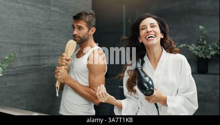 Singing, happy and couple in bathroom in mirror for bonding, having fun and relax together. Love, marriage and woman and man for wellness, playful and Stock Photo