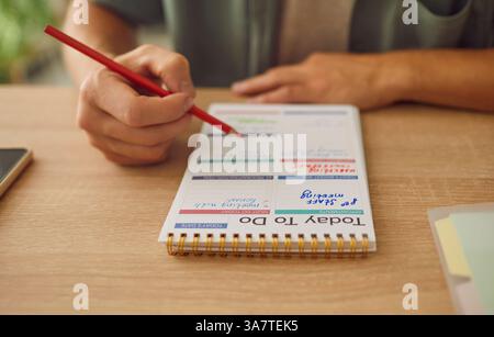 Man fills out diary to do list for today for daily planning and organization. Stock Photo