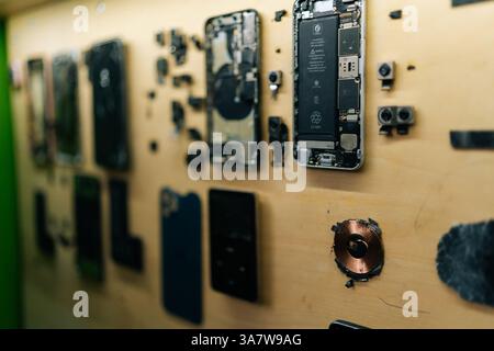 Close-up of several disassembled smartphones on wall, revealing intricate internal components for in-depth analysis and efficient repair Stock Photo