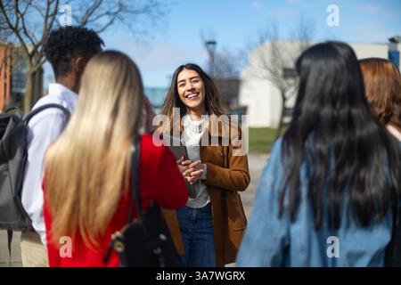 Happy diverse university students chatting together on campus, enjoying their break between classes Stock Photo