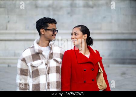 Young fashionable couple looking at each other and smiling during a romantic moment outdoors Stock Photo