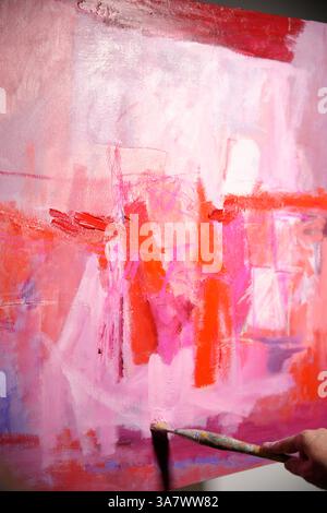 brush painted a picture in pink colors Stock Photo