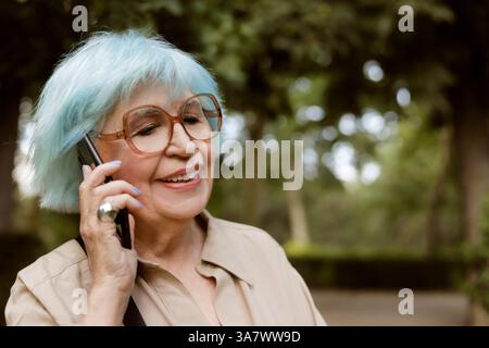 older woman outdoors talking on a cell phone Stock Photo