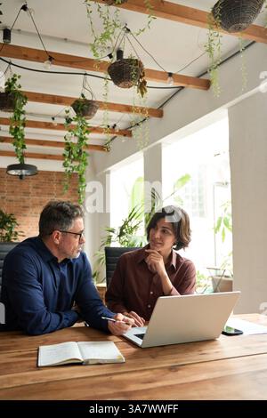 Busy professional executive team managing project using laptop at work. Stock Photo