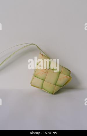 Studio shot of Ketupat, a traditional rice cake casing made from woven young coconut leaves, used during Eid al-Fitr. Isolated on white background. Stock Photo