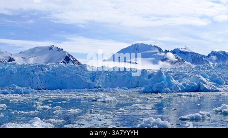 Scenic arctic landscape with glacier, icebergs and snow-capped mountains in the background in Svalbard archipelago, Norway Stock Photo