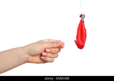 Woman with pin and popped balloon on white background, closeup Stock Photo
