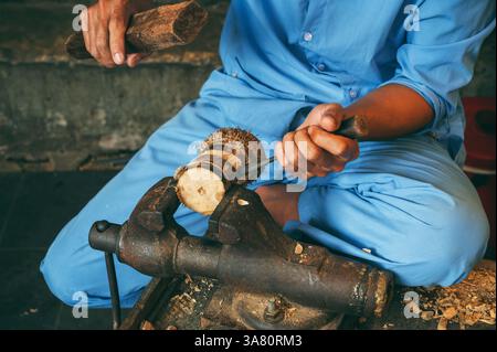 Male hands of a artisan craftsman carpenter wooden carving with a chisel in a workshop in Hoi An in Vietnam in traditional souvenir shop Stock Photo