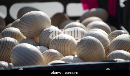 A close-up shot shows wooden eggs piled in a crate, perfect for Easter crafts or rustic decorations with a simple design. Stock Photo