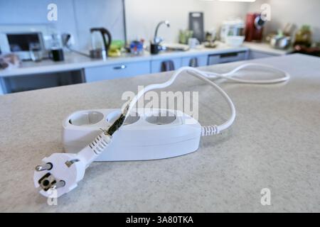 Overload destroyed extension cord, which burned power cable, causing short circuit and almost causing fire. Stock Photo
