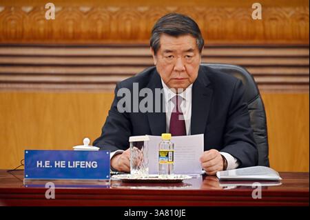 Peking, China. 28th Mar, 2025. He Lifeng (l), China's Vice Premier, sits in the Great Hall of the People. Xi praised China as a safe investment location. Credit: Johannes Neudecker/dpa/Alamy Live News Stock Photo