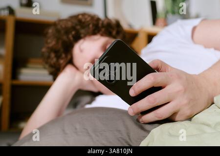 Relaxing on Couch While Holding Smartphone Stock Photo