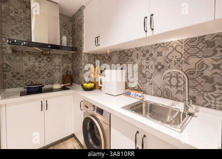 Modern Kitchen with Geometric Tile Backsplash and Integrated Appliances Stock Photo