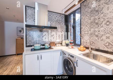 Modern Kitchen with Geometric Tile Backsplash and Integrated Appliances Stock Photo