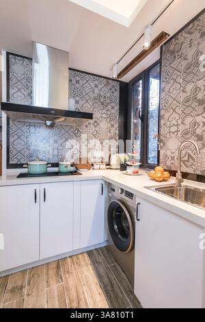 Modern Kitchen with Geometric Tile Backsplash and Integrated Appliances Stock Photo