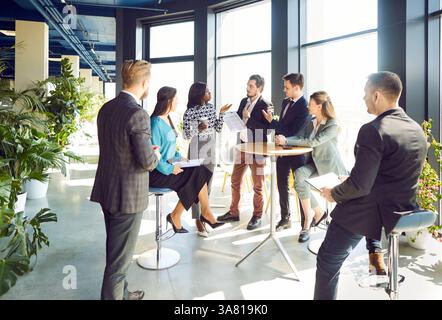 Business people diverse group and executive leader talking to happy employees Stock Photo